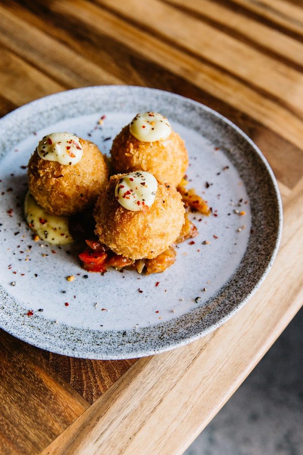 Come fare degli arancini di riso al burro con cuore di mozzarella filante?